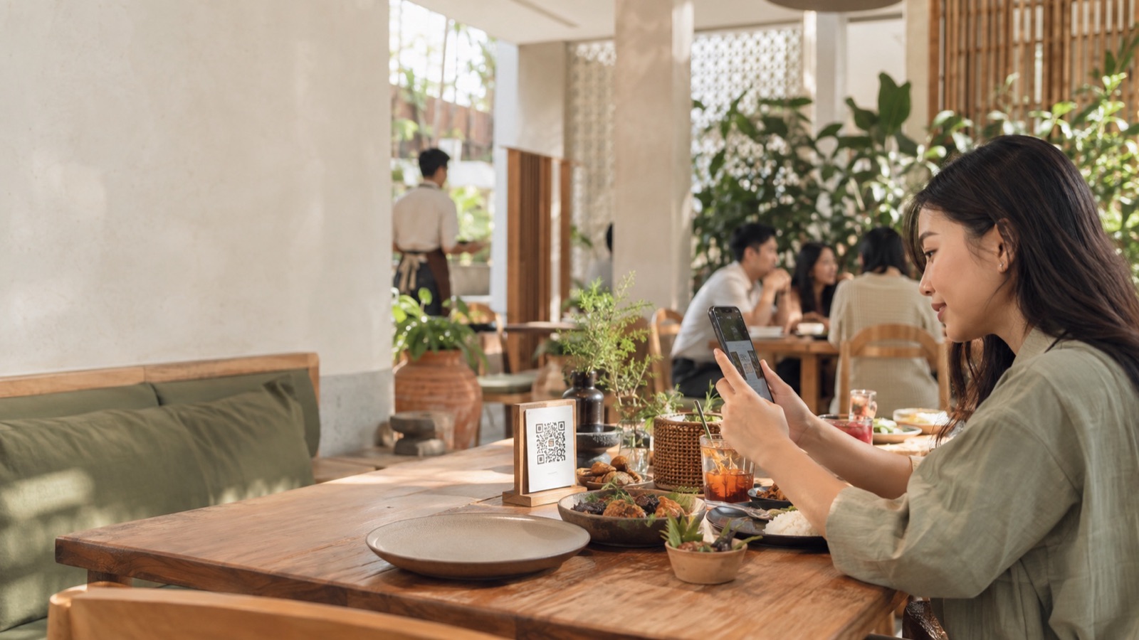 Pelanggan memindai QR menu di meja restoran